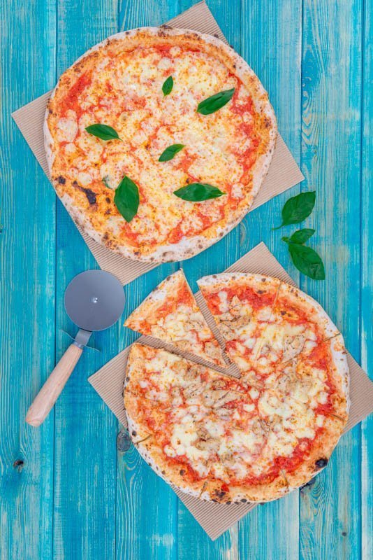 Basil Pizza with Chicken Pizza on Blue Wood Background with Pizza Cutter