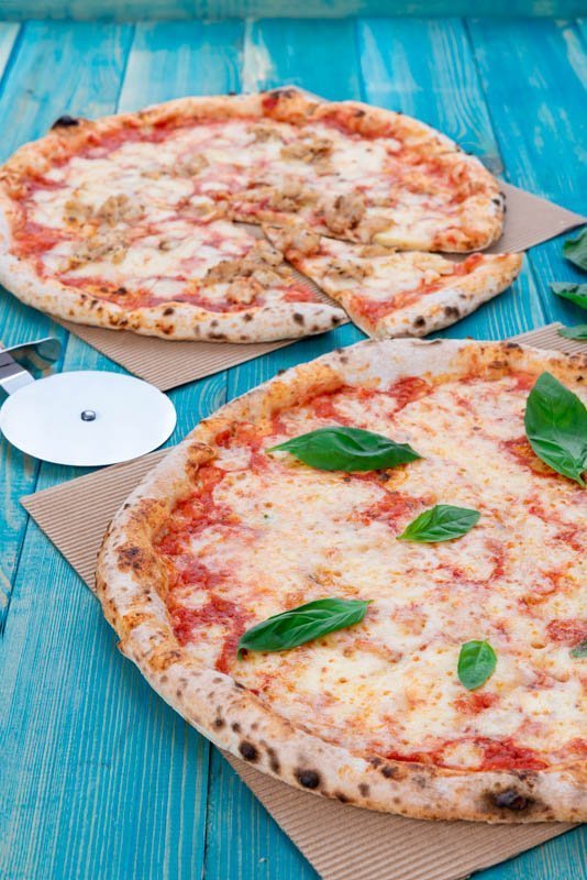 Basil Pizza with Chicken Pizza on Blue Wood Background with Pizza Cutter