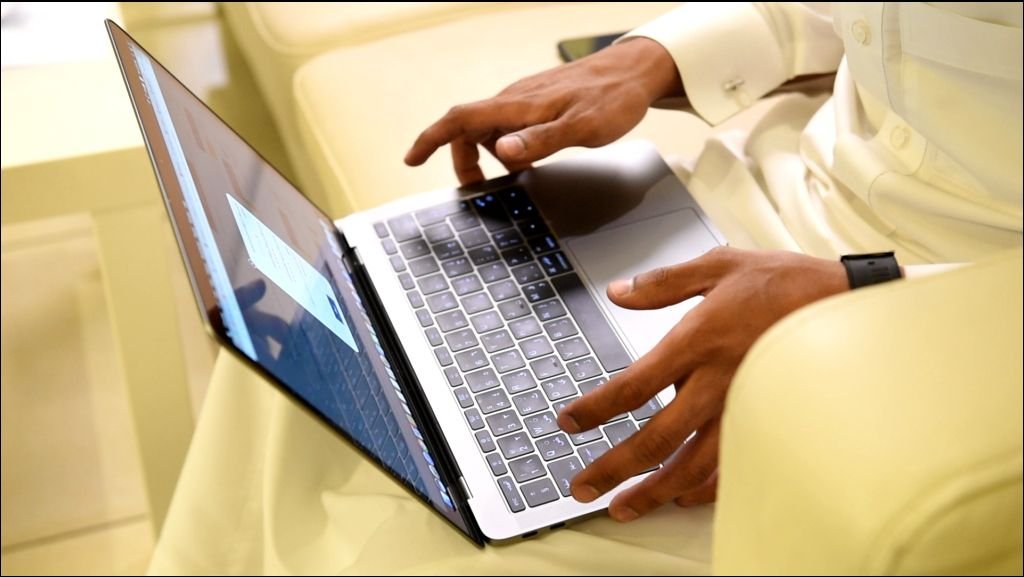 Arabic man working on laptop and mobile